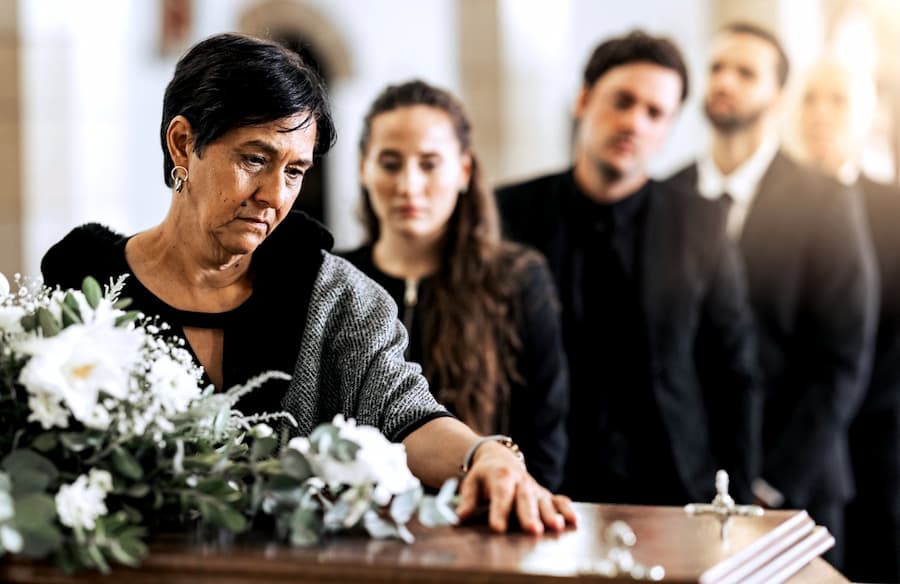 mother staring at her sons coffin during funeral