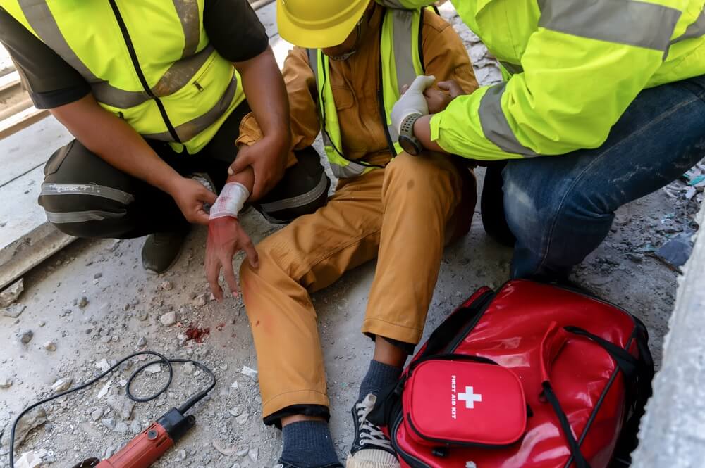 First aid team support to builder worker after hand injury bleeding, accident at work, Using construction power tools unsafe and negligence at the construction site.