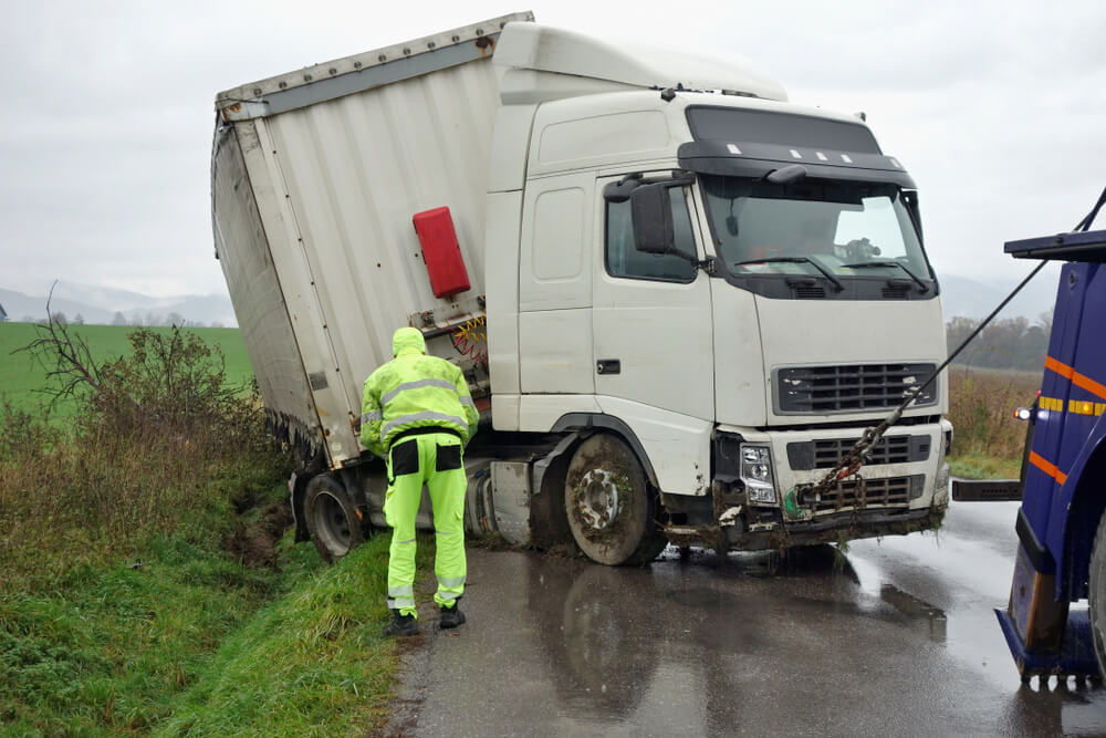 The truck lies in a ditch after the road accident.