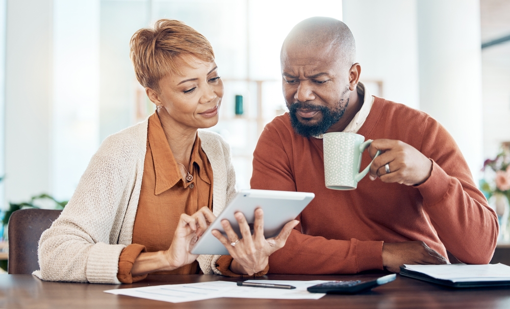 couple evaluating their options by looking at an ipad