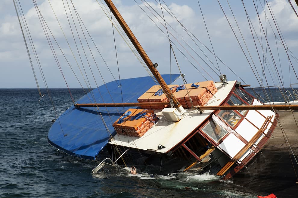 A schooner listing to its side and slowly sinking