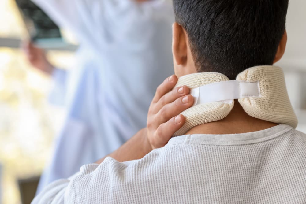 Young Man with Neck Injury Visiting Doctor in Clinic