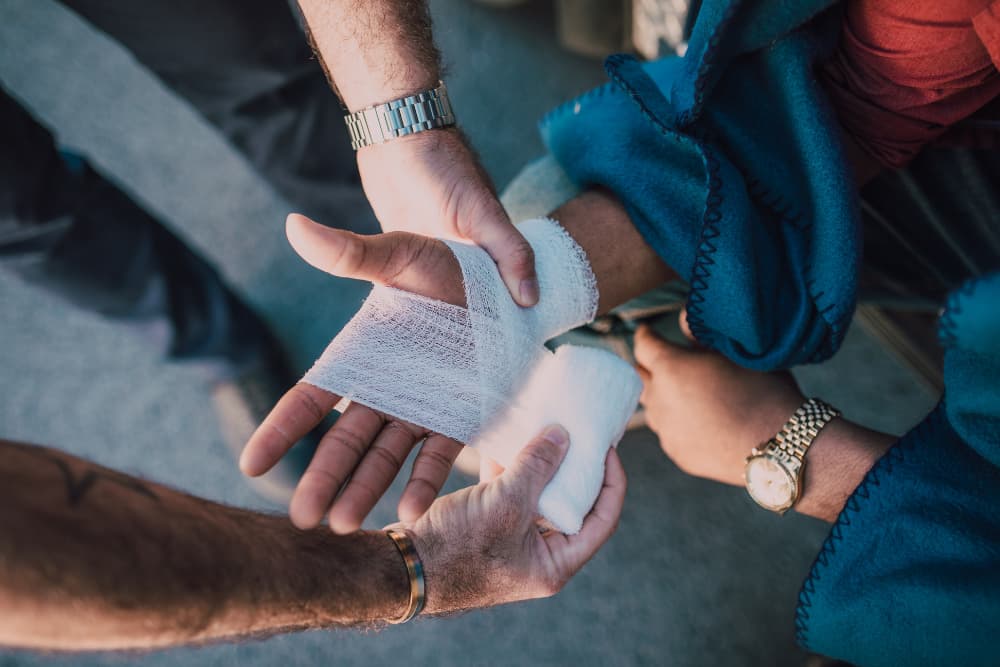person applying bandage on injured pedestrian