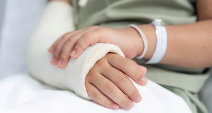 Closeup of a Kid's Injured Arm Wrapped in Bandage