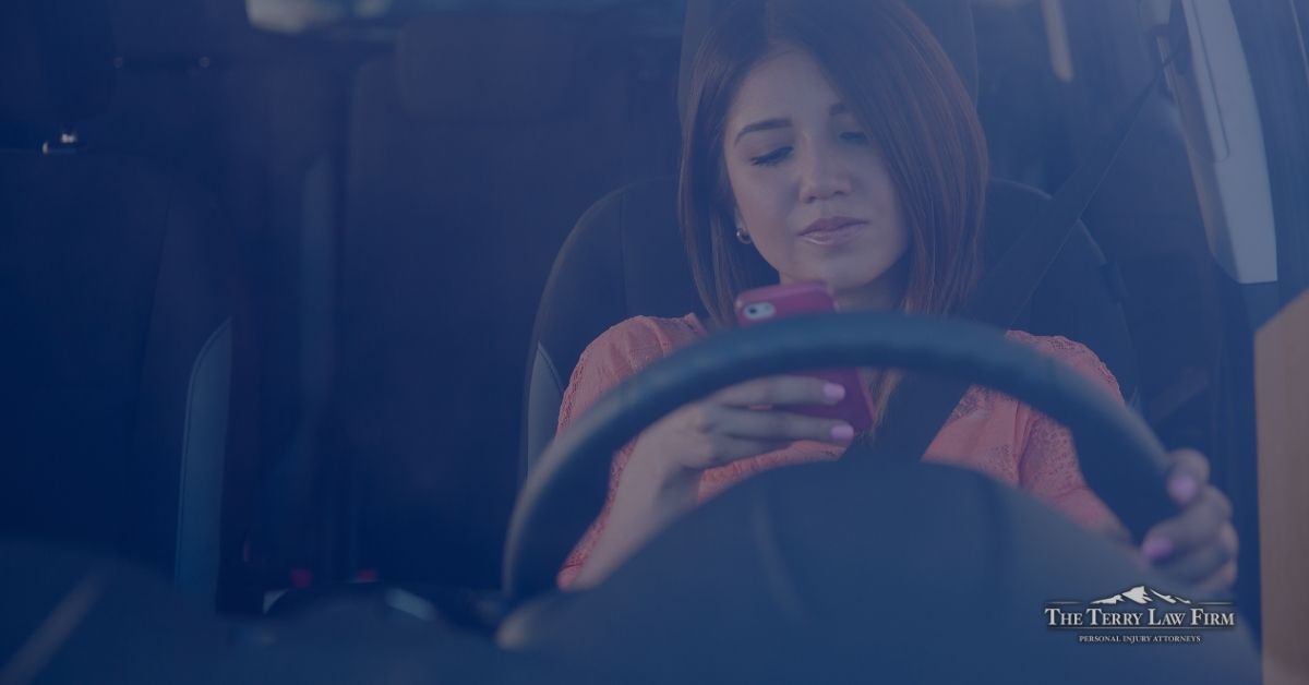 Driver looking down at a cell phone while behind the wheel on a Greeneville, Tennessee road